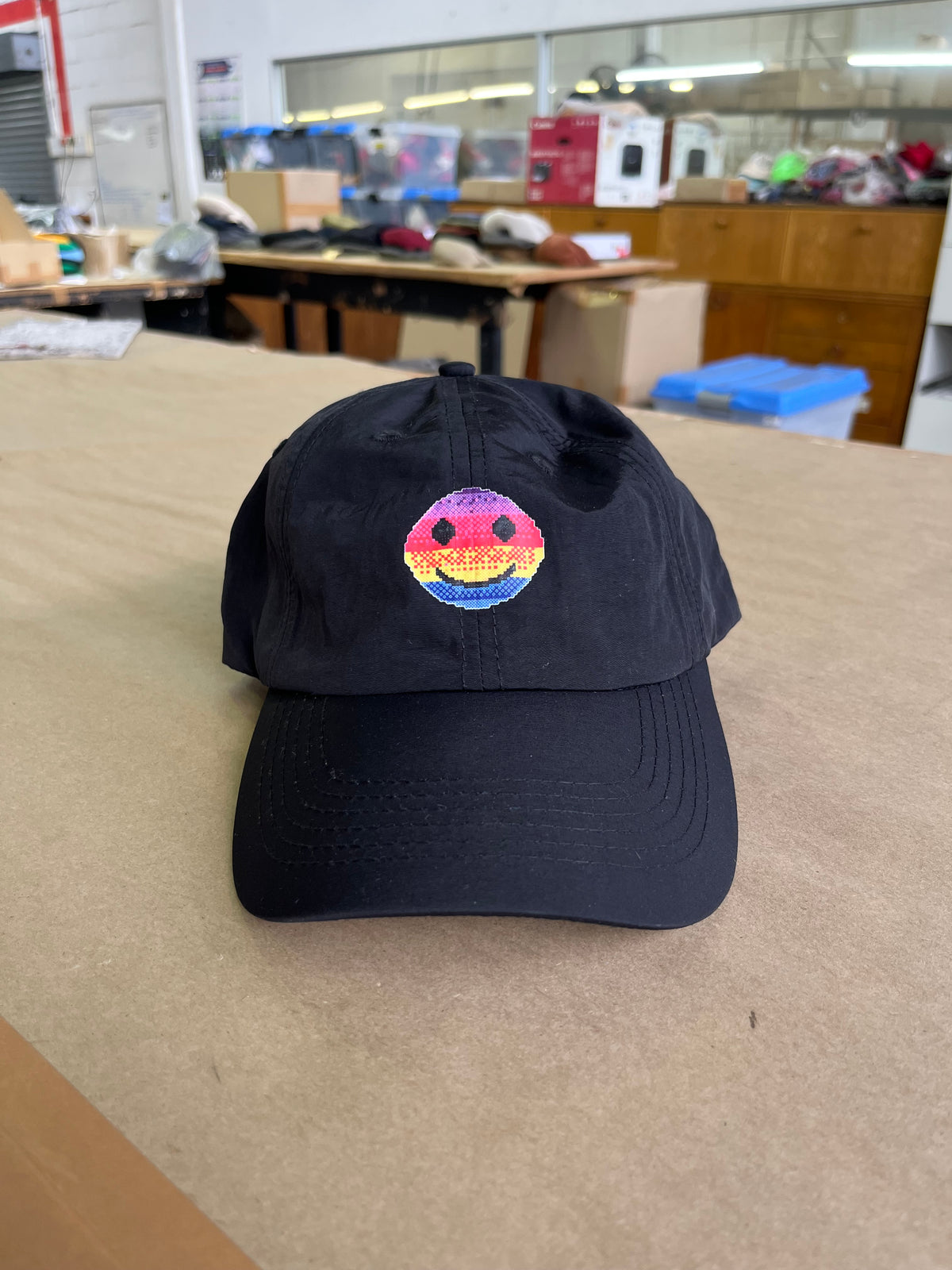 A smile cap viewed from the front, resting on a tan surface in a workshop